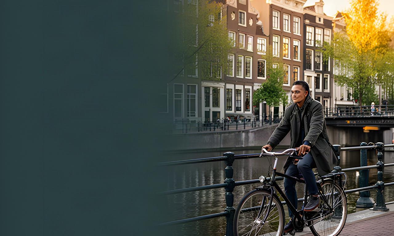 Expat met fiets langs een Amsterdamse gracht, met historische gevels en rustig ochtendlicht